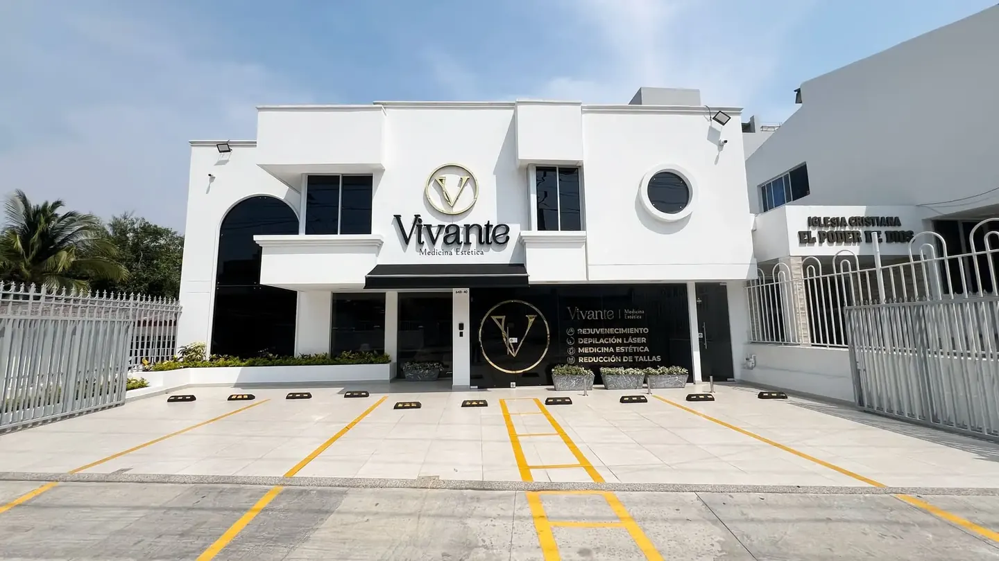 Fachada blanca de Vivante en la Calle 86, Riomar, con ventanas redondas y el monograma dorado
